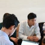 A group of colleagues in a business meeting using laptops for planning and teamwork.